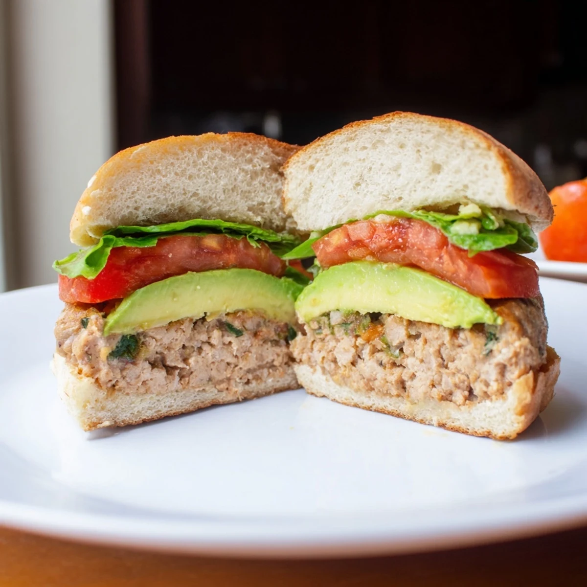 A juicy Turkey Burger with Avocado Slices served with crisp lettuce and red onion.