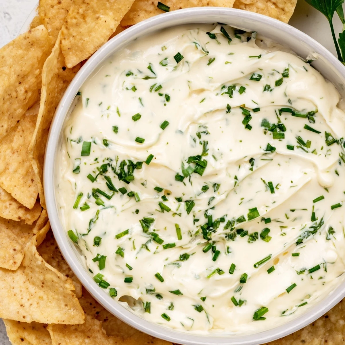 Close-up of Creamy Dip Bowl with a smooth, tangy texture, served beside crisp chips and fresh lemon wedges for a bright flavor boost.