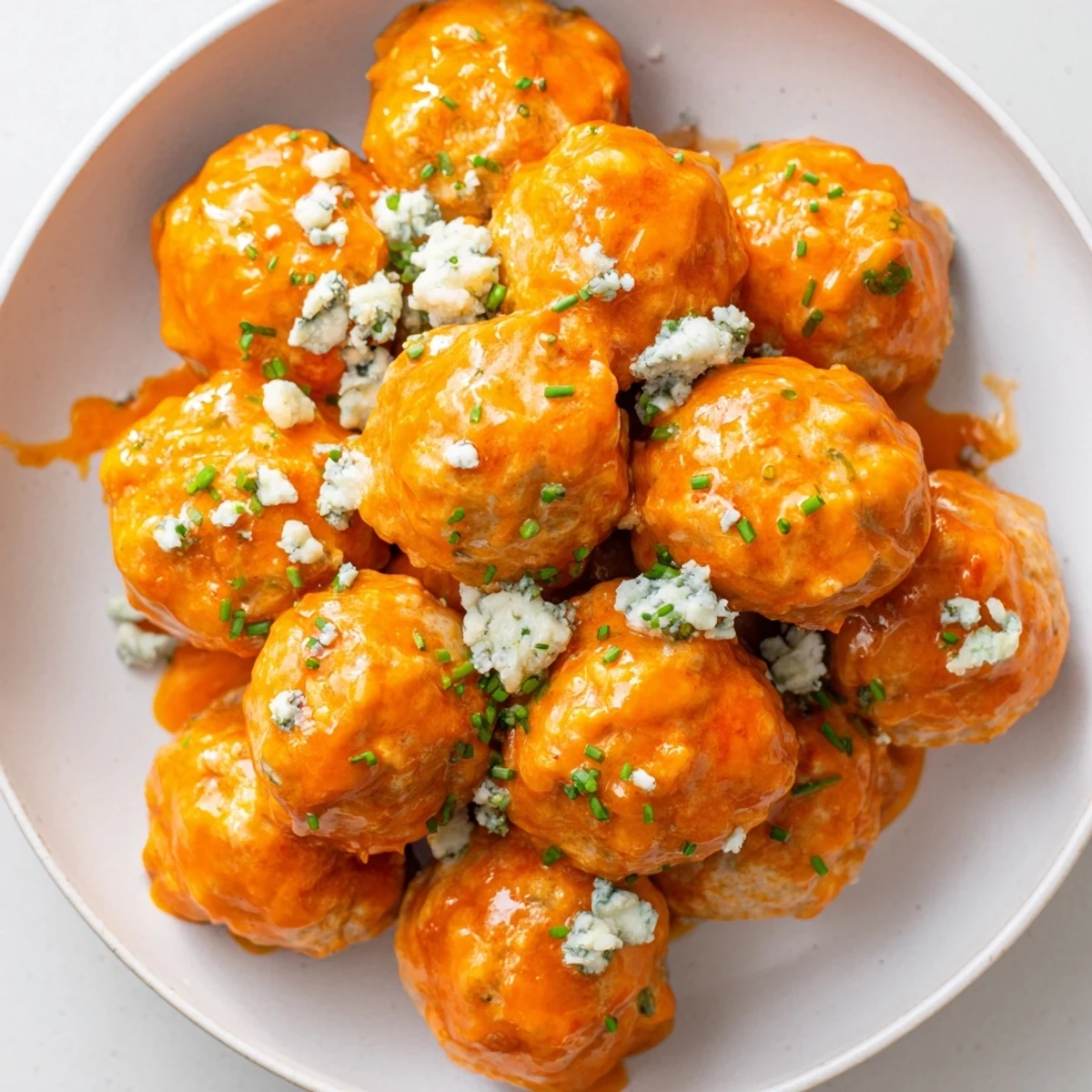 Tender Buffalo chicken meatballs paired with crisp celery sticks and a side of crumbled blue cheese for dipping.