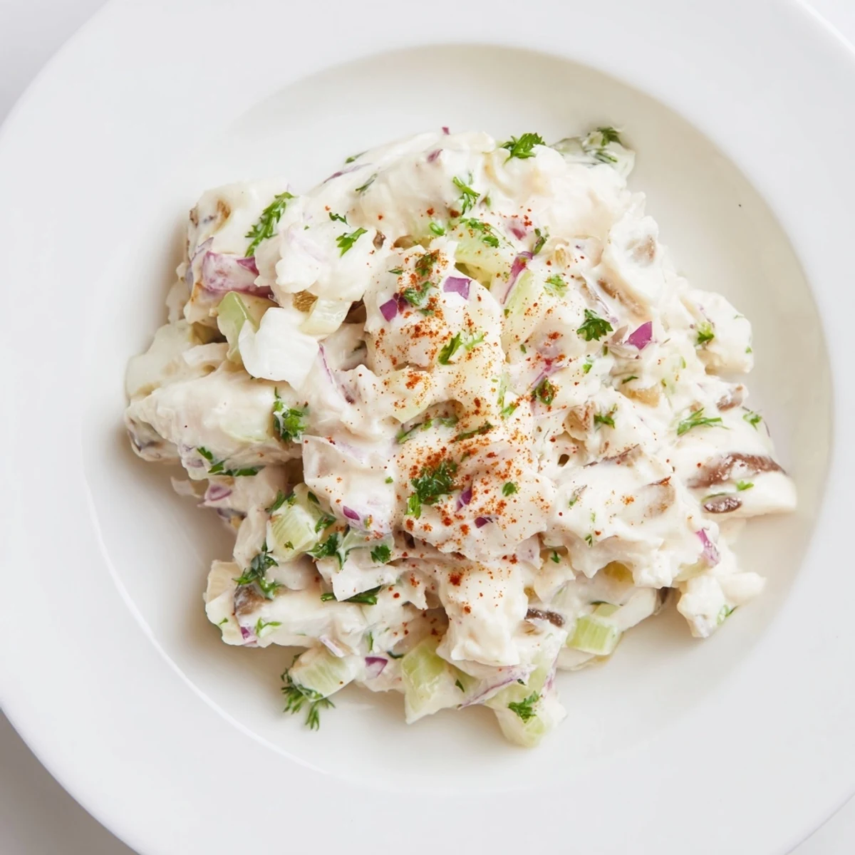 Zesty remoulade sauce with crab meat and herbs served chilled on crackers, ideal for a party dip.