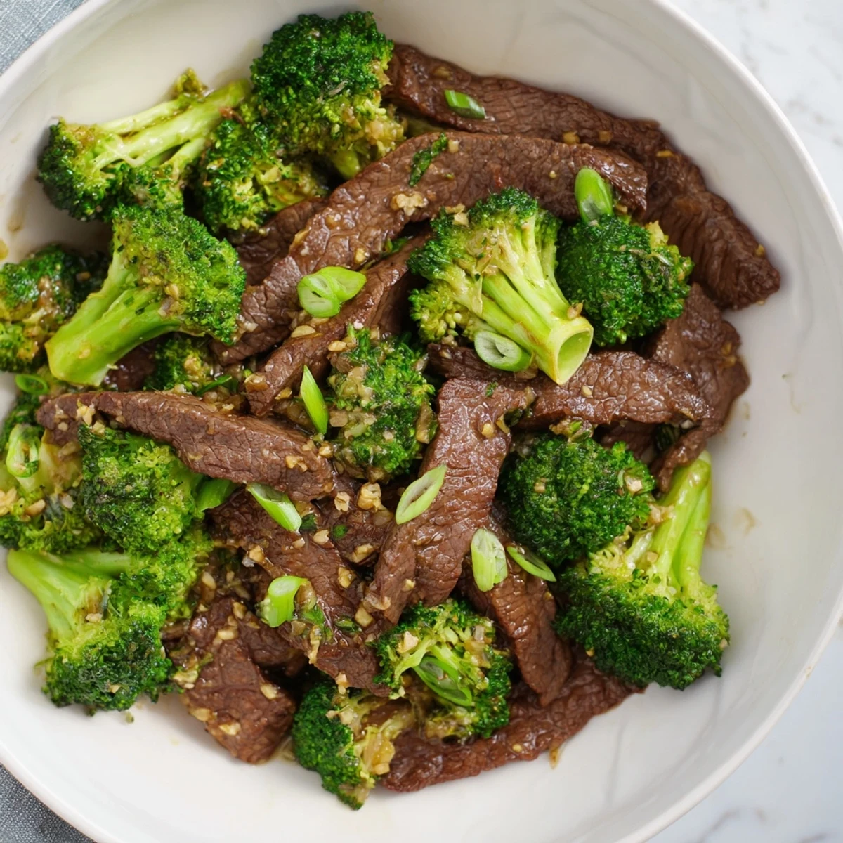 Wok-fried Beef and Broccoli Stir Fry with Ginger Sauce plated with noodles, steaming aromatic ginger and garlic sauce coating the beef and broccoli florets beautifully.