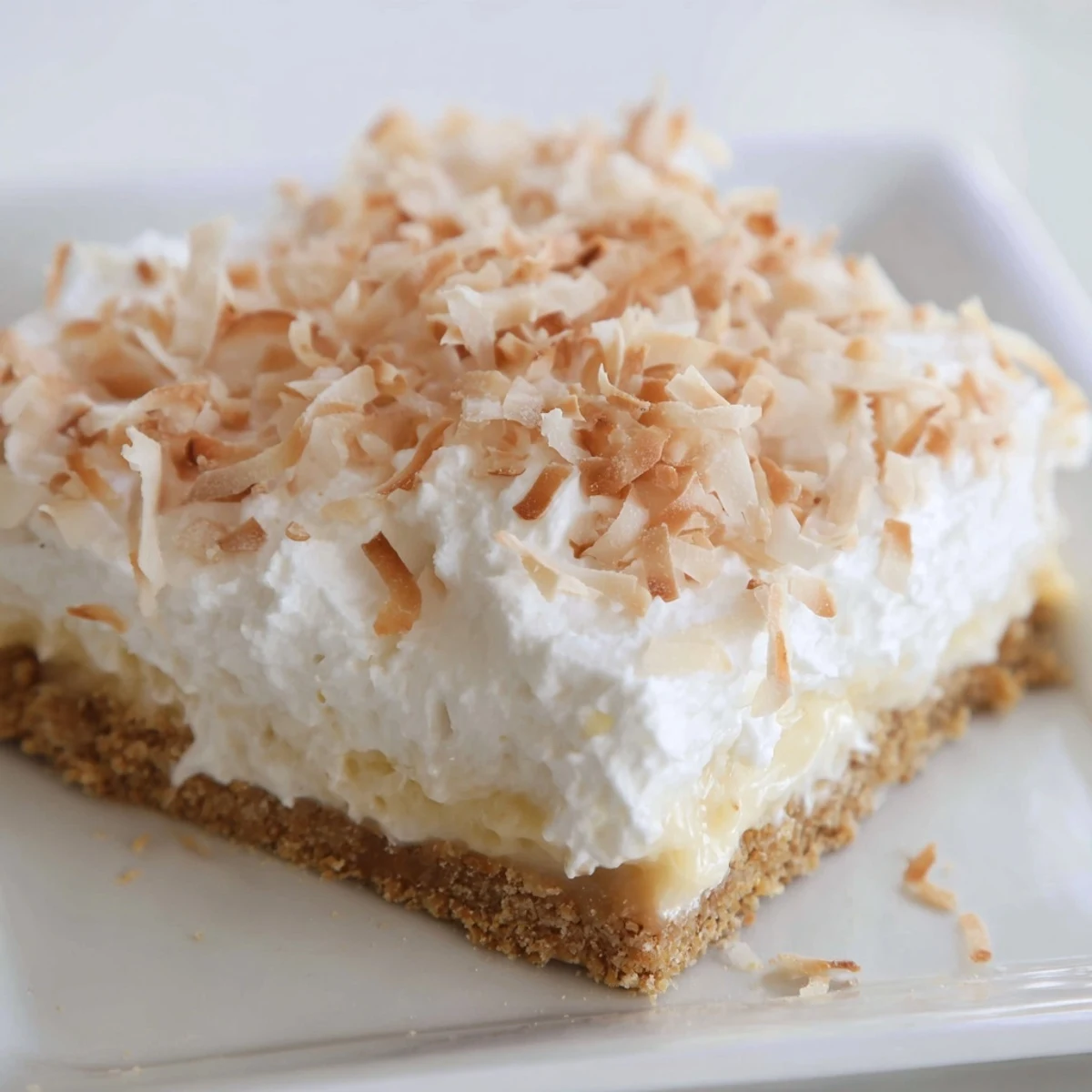 Homemade Coconut Cream Dream Bars with a graham cracker crust and creamy filling, ready to serve.