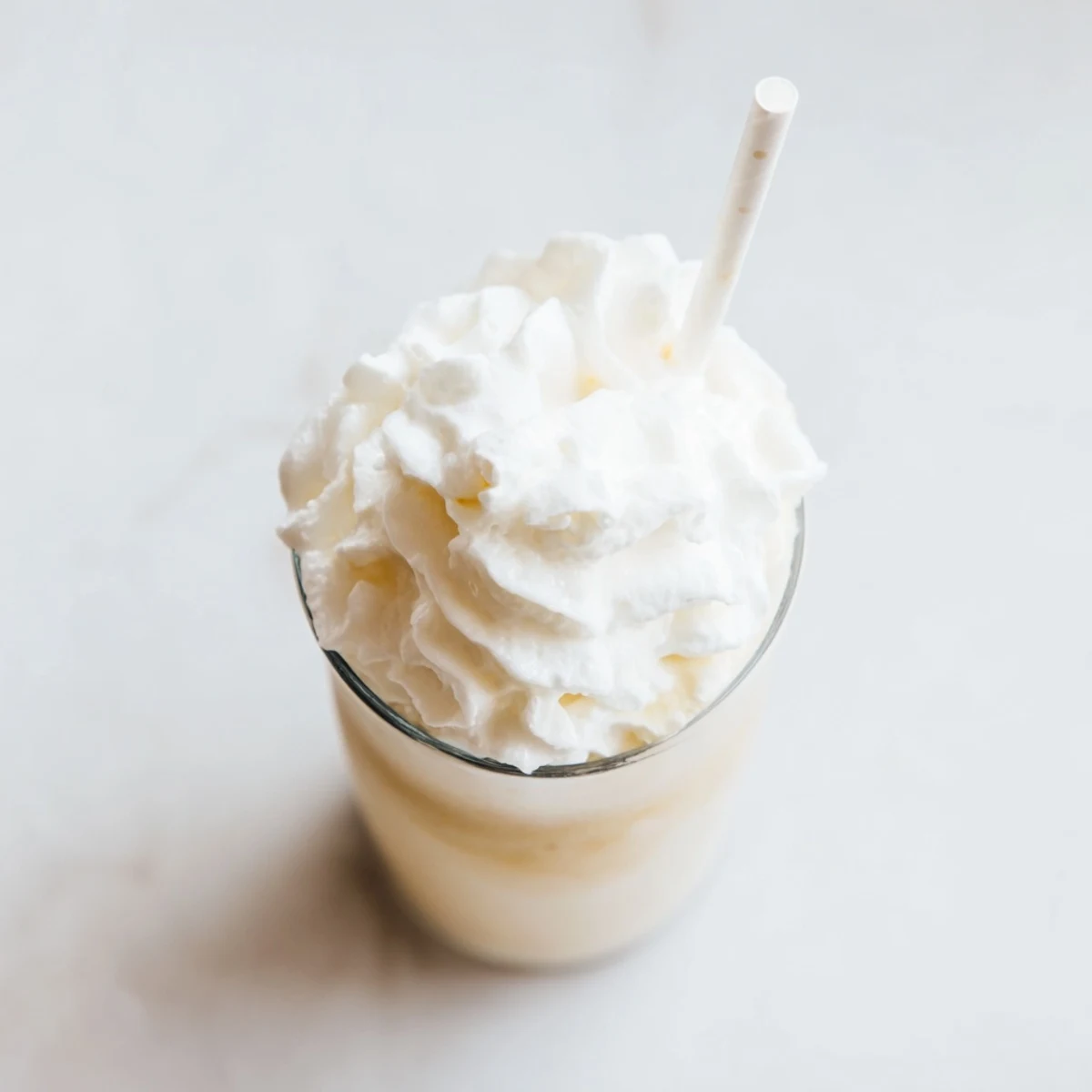 Cold blended Starbucks Vanilla Bean Frappuccino served with a straw and sweet vanilla aroma.