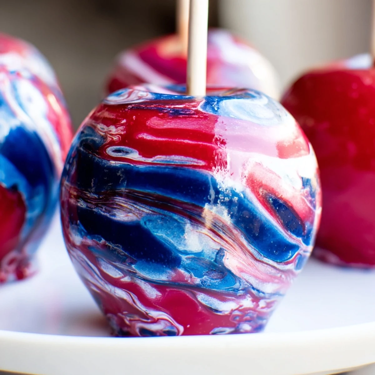 Eight Marbled Effect Candy Apples with wooden sticks, arranged on a white plate for a whimsical dessert presentation.