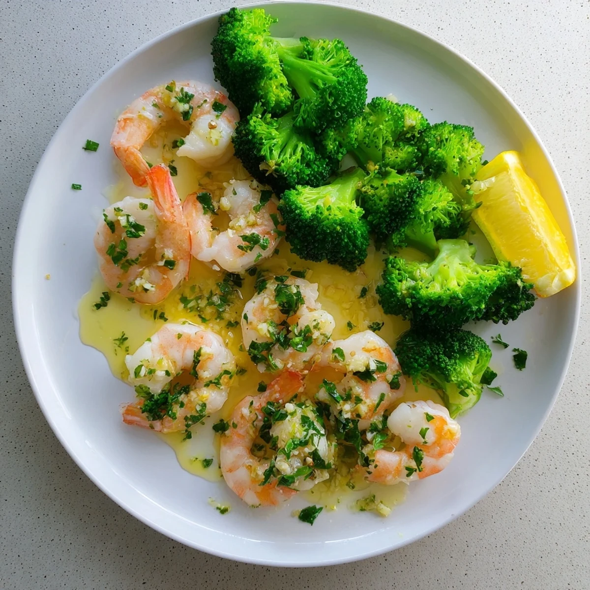 Juicy honey garlic butter shrimp and bright broccoli florets tossed and glistening on a plate with rice.