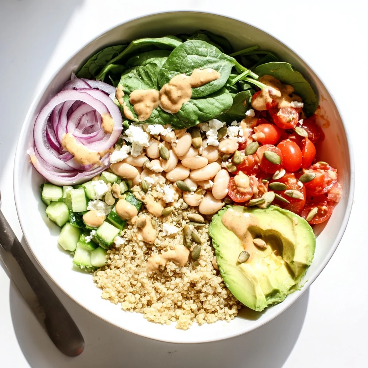 Fresh spinach and white beans shine in this Spinach & White Bean Ultimate Protein Power Bowl topped with juicy cherry tomatoes.