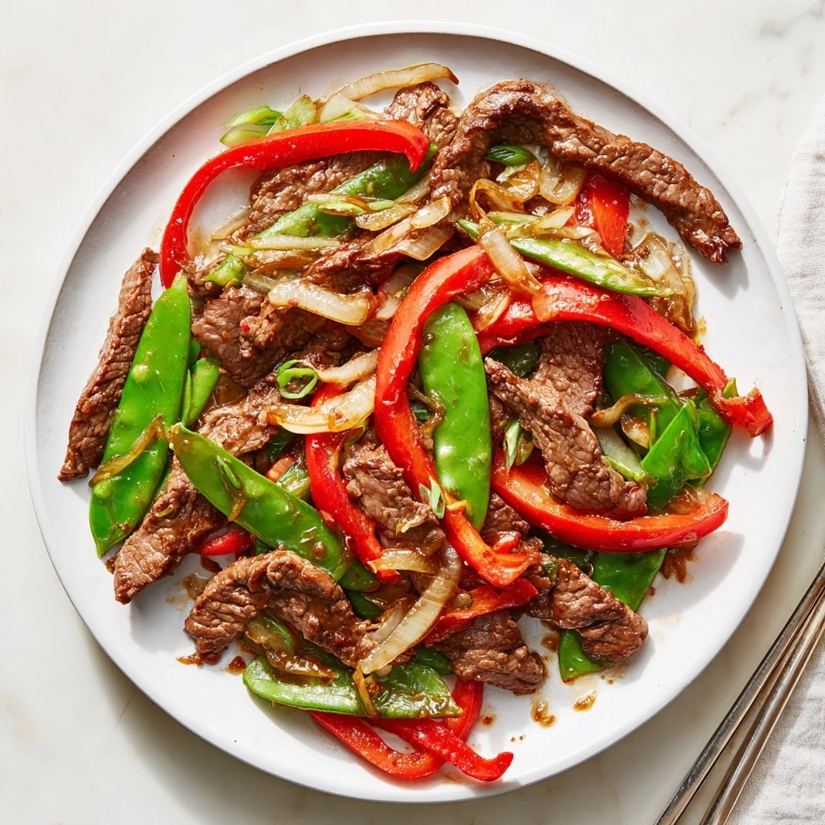 A close-up of Beef with Oyster Sauce served over fluffy jasmine rice with garlic and ginger aromas.