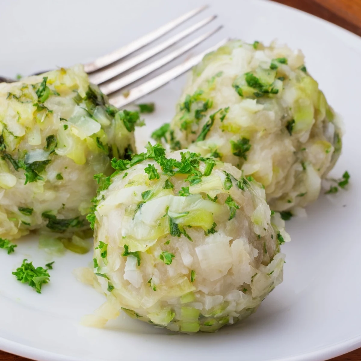 Freshly simmered German Cabbage Dumplings with tender filling and aromatic parsley garnish.  