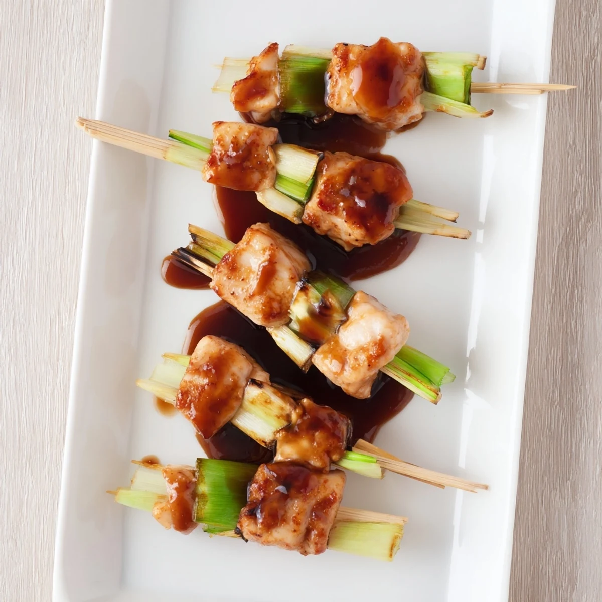 Grilled Japanese chicken yakitori pieces basted in savory sauce on bamboo sticks