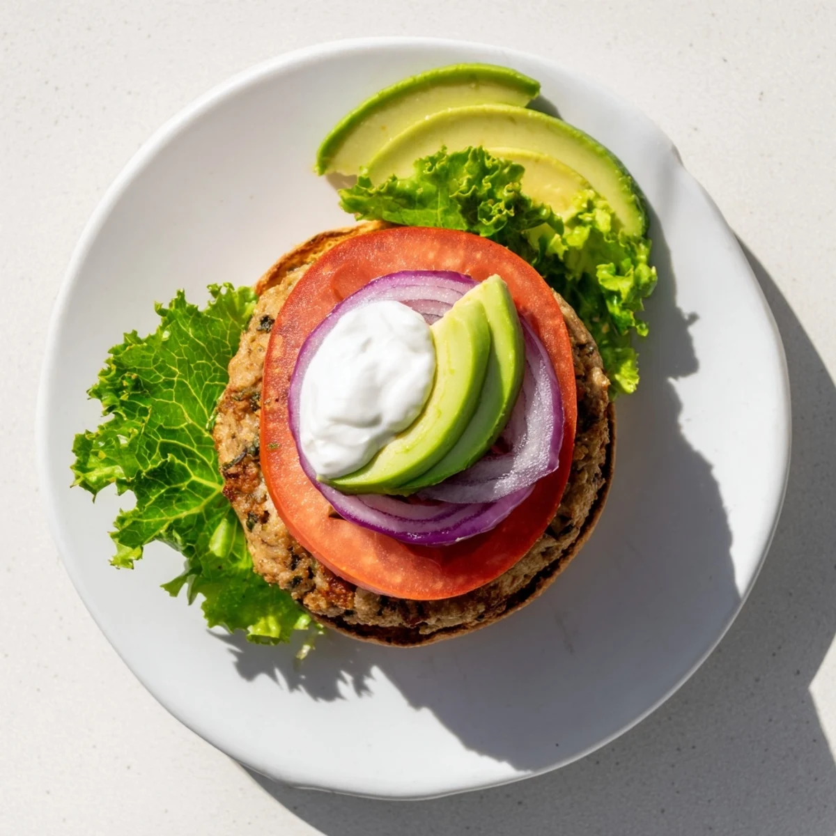 Juicy healthy high protein burger sandwiched between toasted whole wheat buns with crisp lettuce and ripe tomato slices