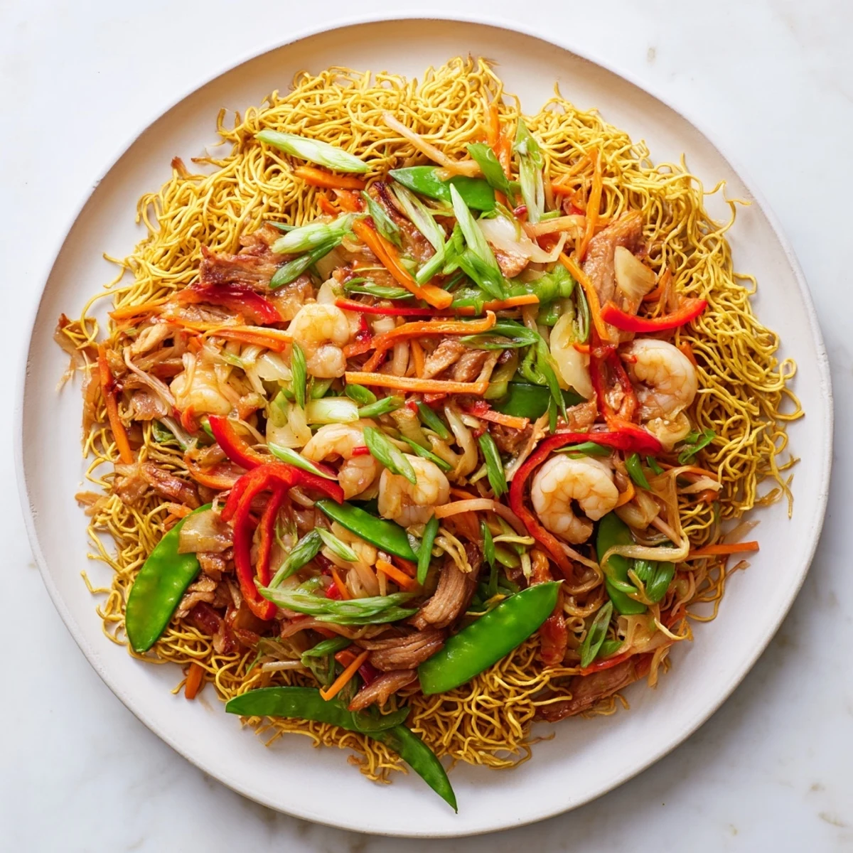 Crispy Cantonese Chow Mein topped with tender chicken, shrimp, and colorful vegetables in savory brown sauce