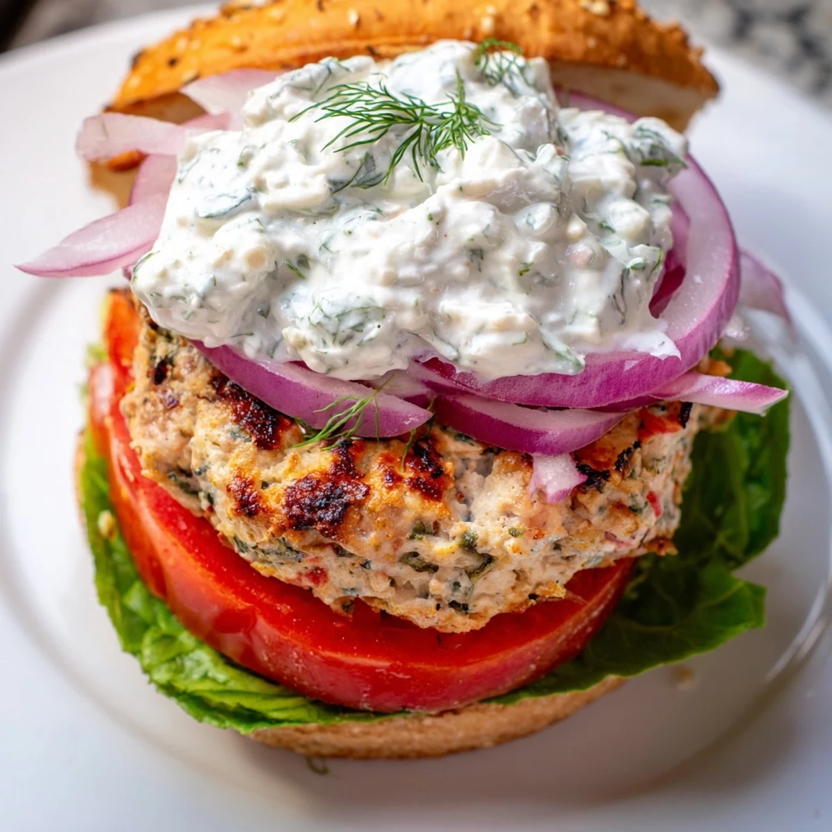 Mediterranean style chicken patties layered with fresh vegetables and tangy yogurt sauce