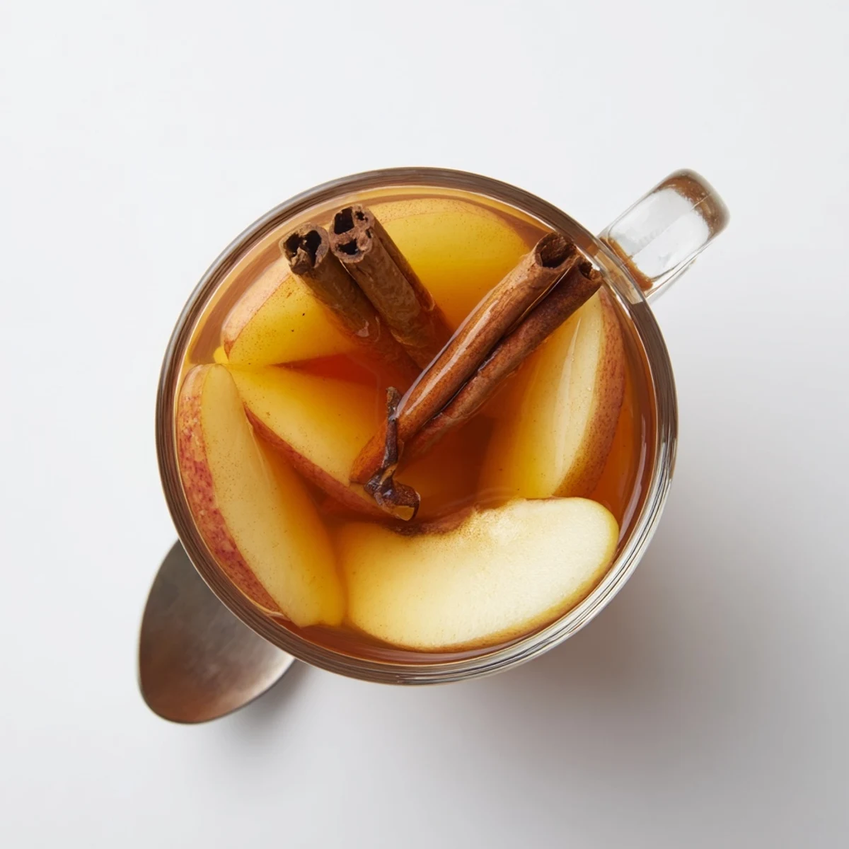 Steaming mug of cinnamon pear cider garnished with fresh pear slices and cinnamon stick