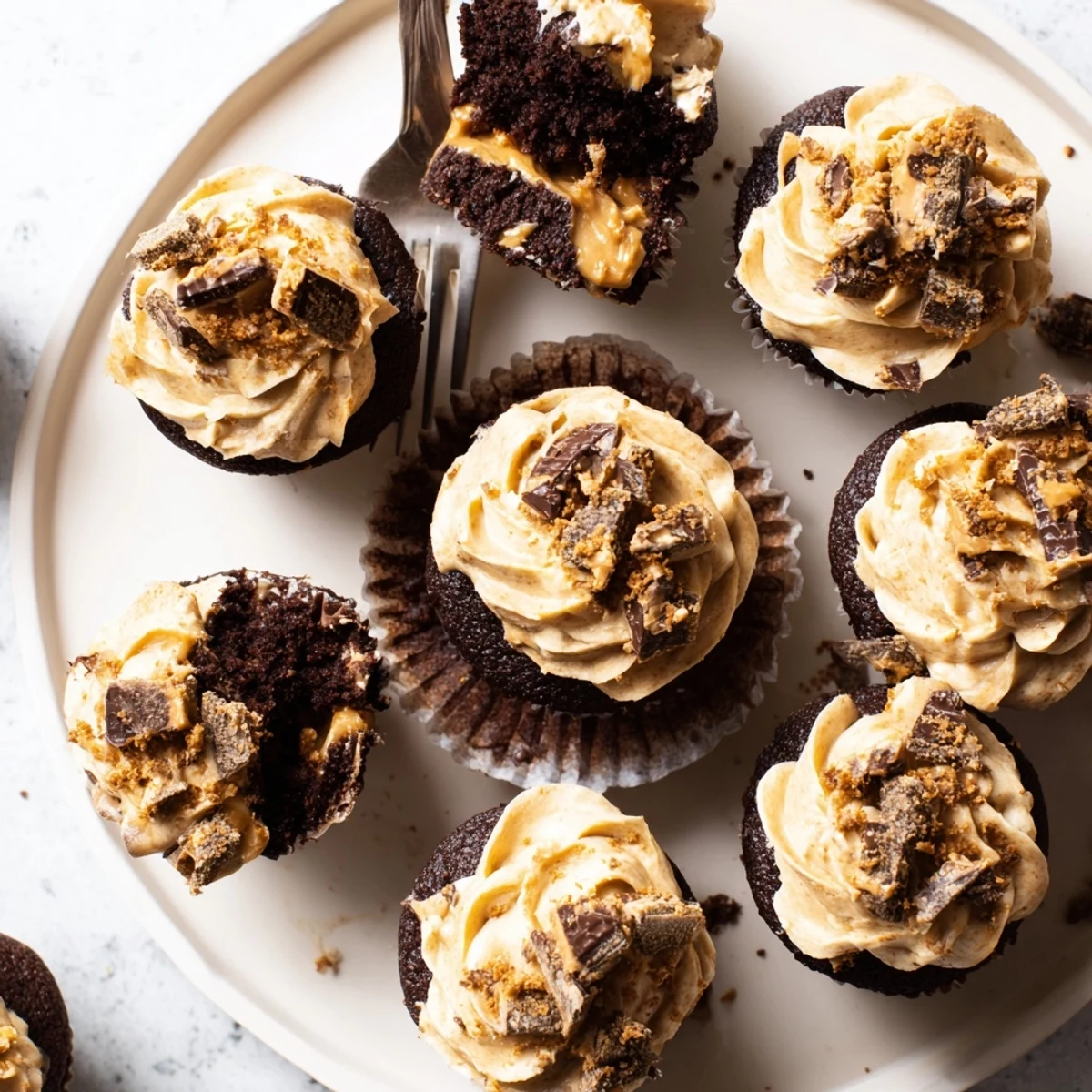 Rich chocolate Decadent Butterfinger Cupcakes topped with creamy peanut butter frosting and crunchy candy pieces