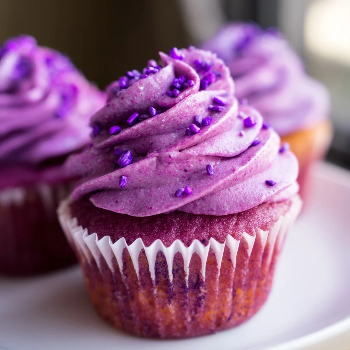 Close-up of vibrant purple grape soda cupcakes with tangy buttercream and grape soda splash garnish.