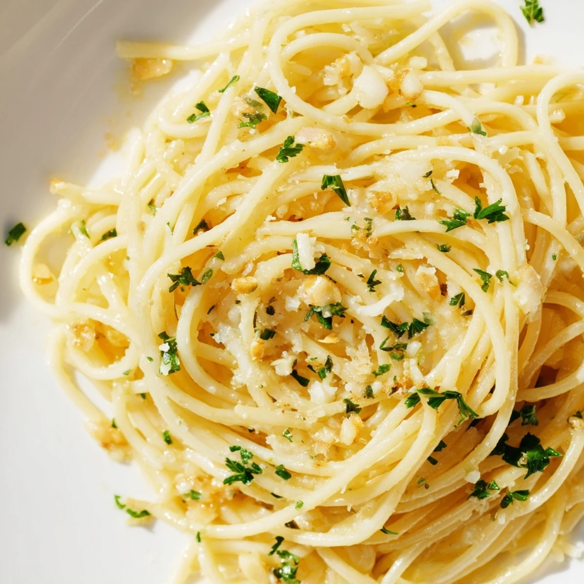 Golden strands of one pot garlic butter pasta coated in creamy parmesan sauce with fresh parsley garnish