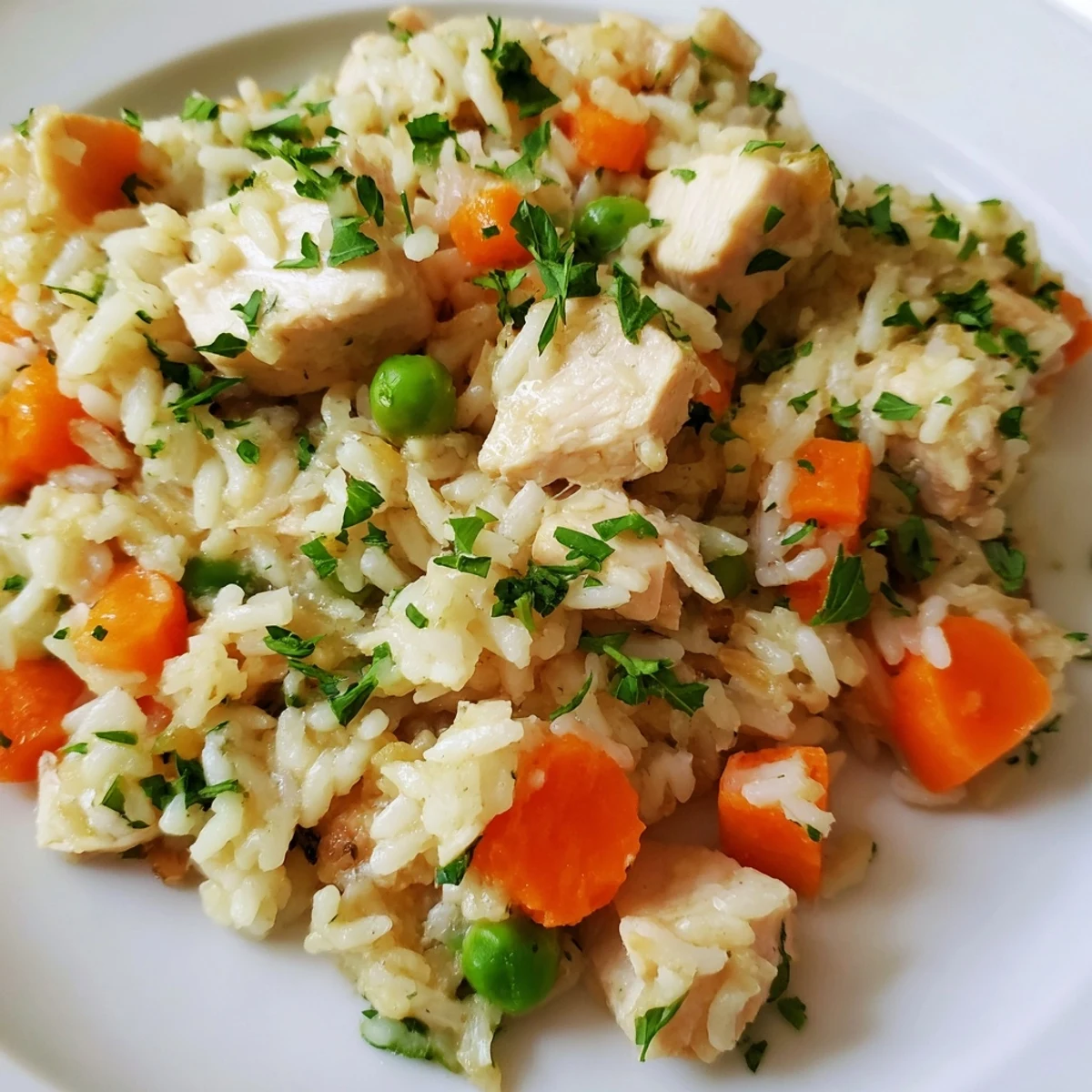 Golden Instant Pot chicken and rice served in a white bowl with fresh green parsley garnish