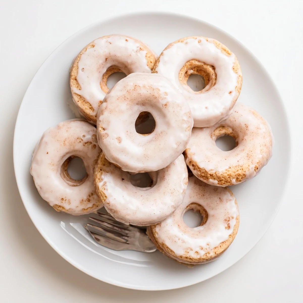 Light and fluffy Greek yogurt cake donuts fresh from the oven with cinnamon dusting and drizzle of white icing
