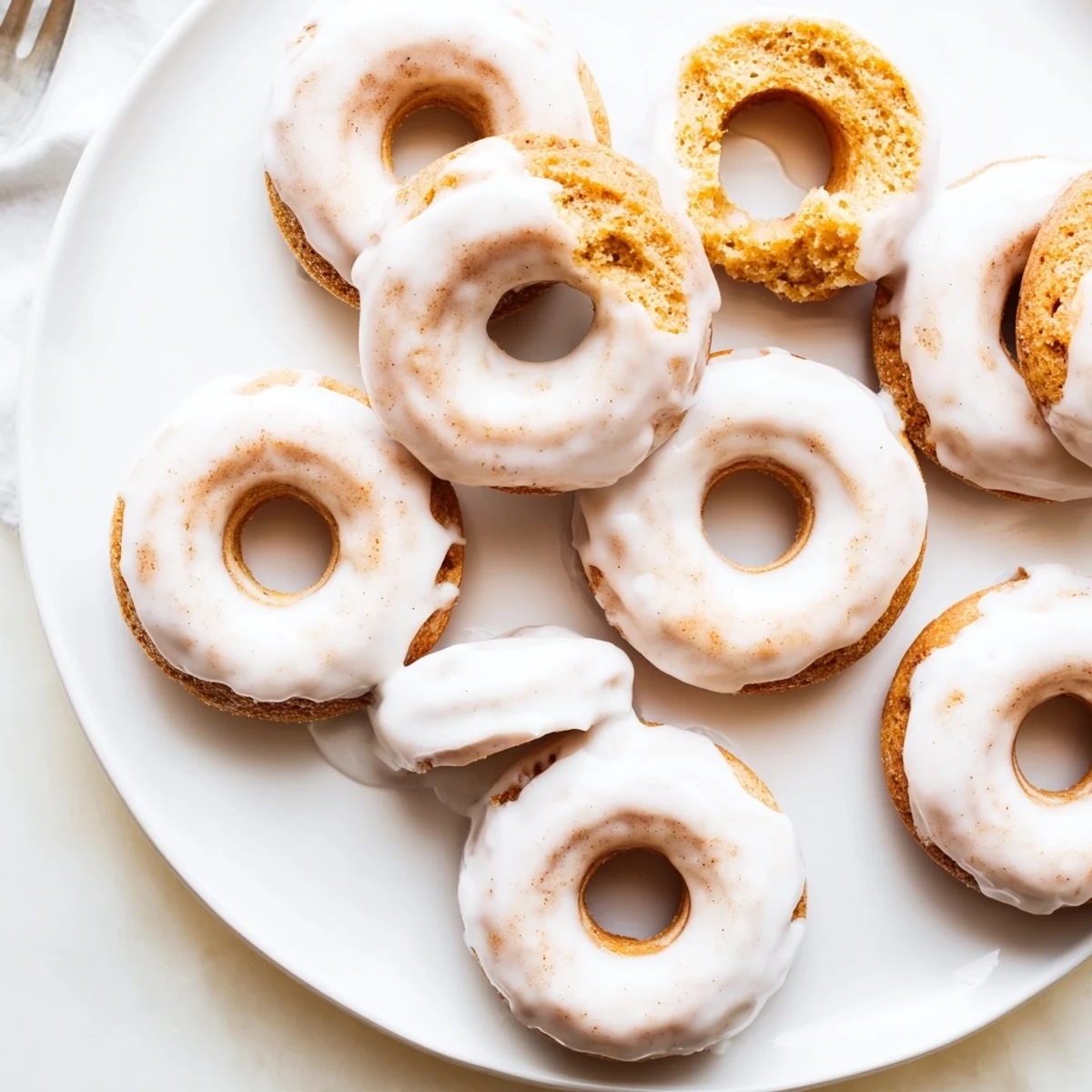 Close-up of moist Greek yogurt cake donuts with glossy sugar glaze resting on a wire cooling rack
