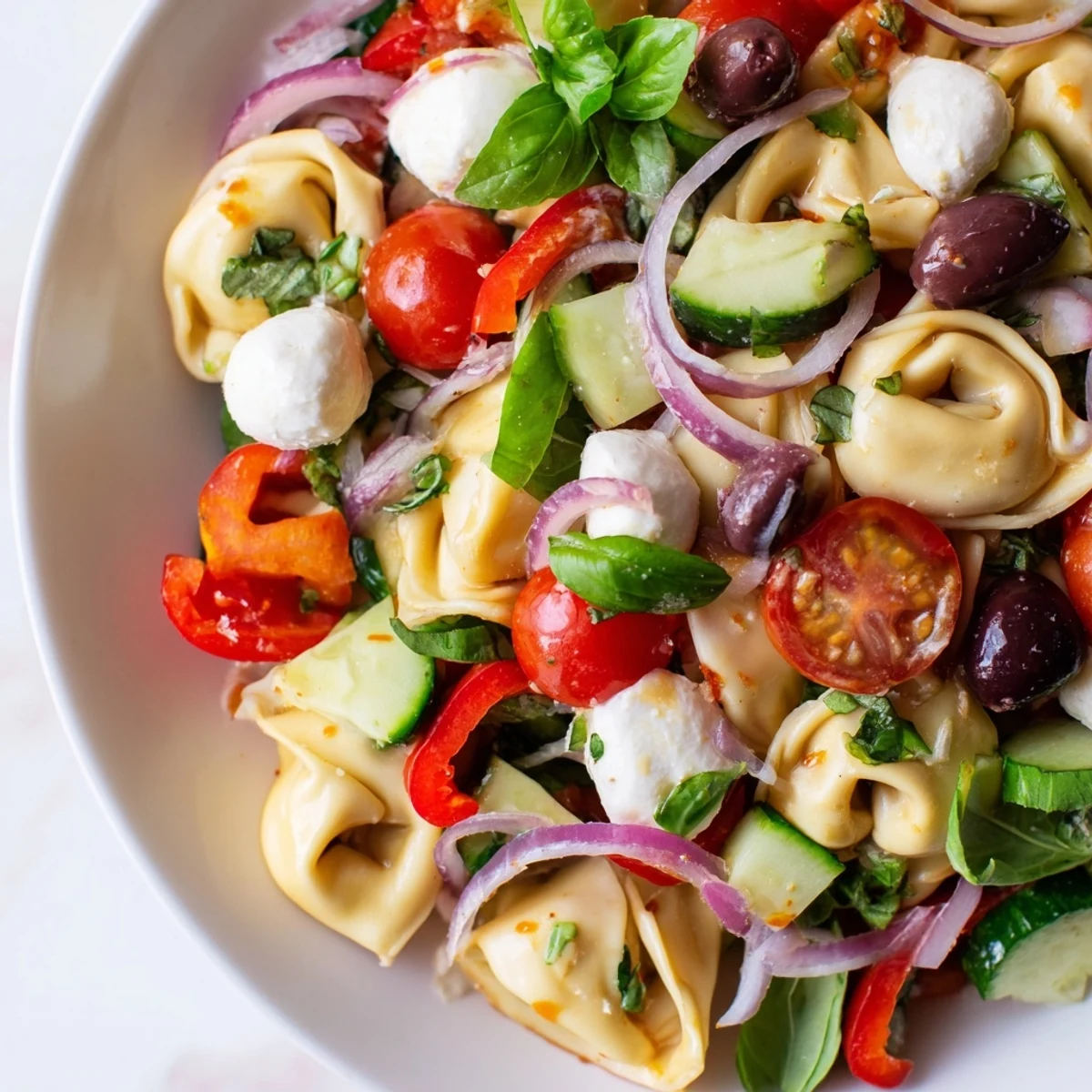 Tortellini salad tossed with crisp vegetables and fresh basil in a tangy vinaigrette