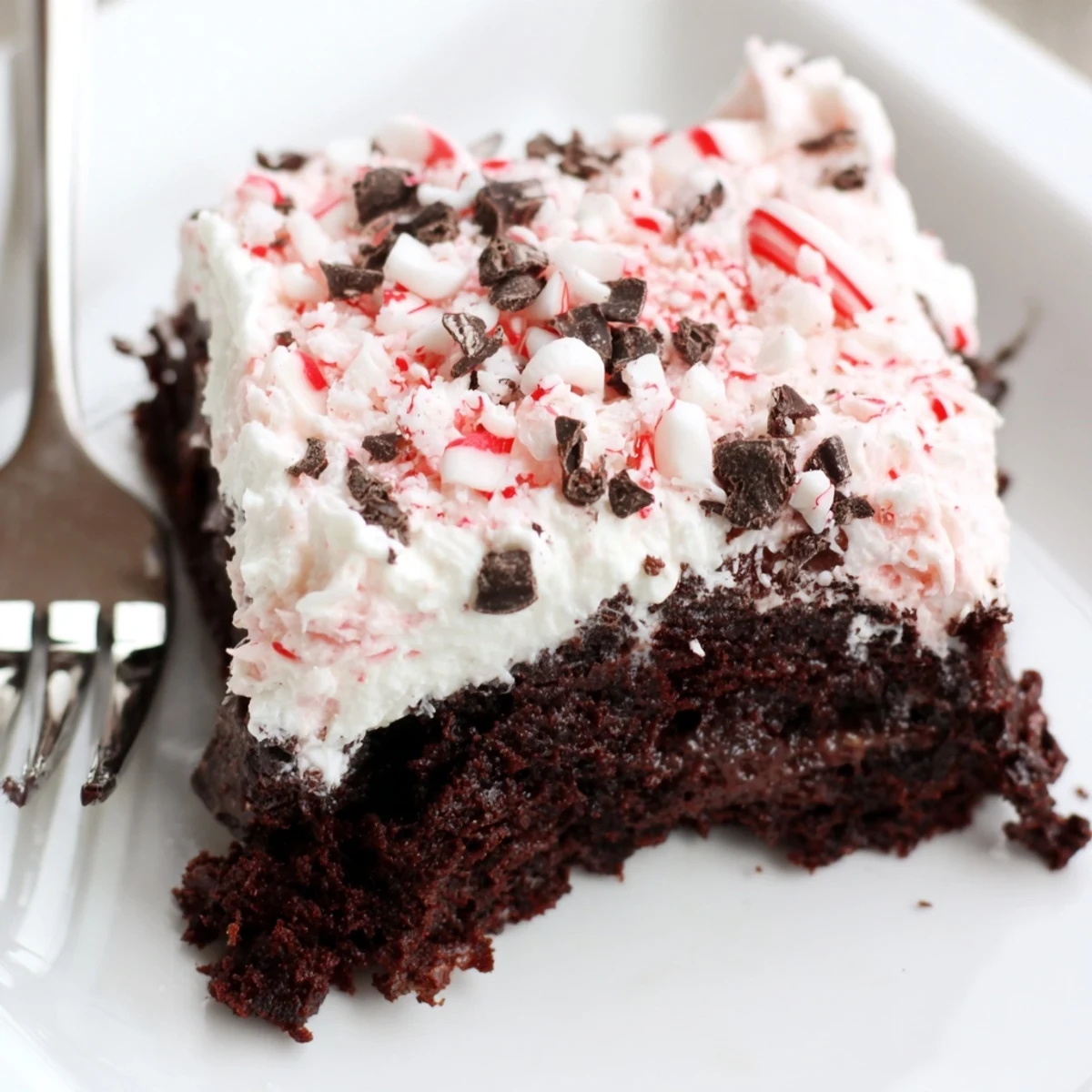 Festive Peppermint Poke Cake: moist chocolate, minty pudding filling, snowy whipped cream.