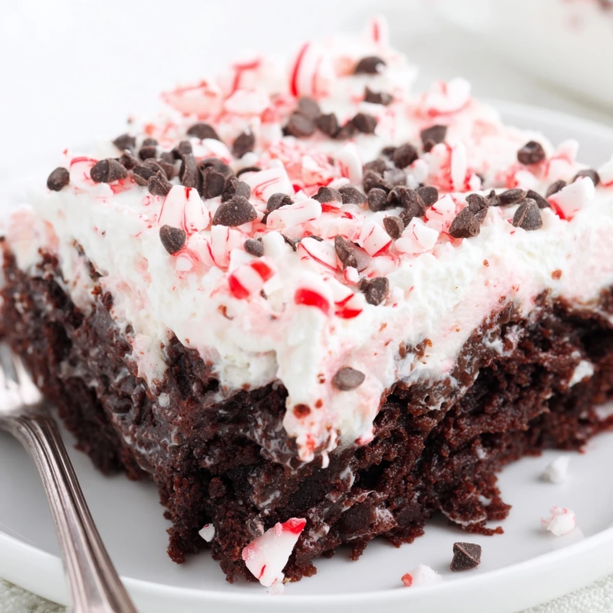 Close-up view of Peppermint Poke Cake with cool mint filling and crushed peppermint.