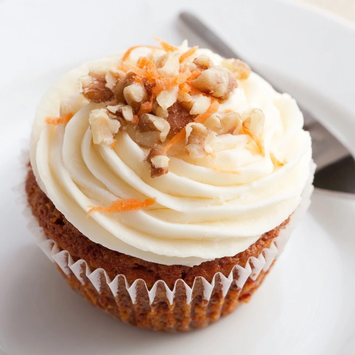 A stack of Moist Carrot Cake Cupcakes beside a cup of chai
