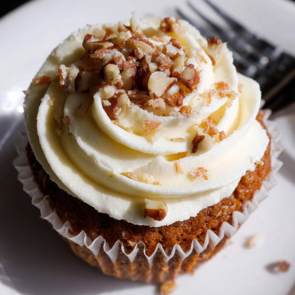Moist Carrot Cake Cupcakes topped with creamy frosting and toasted pecans