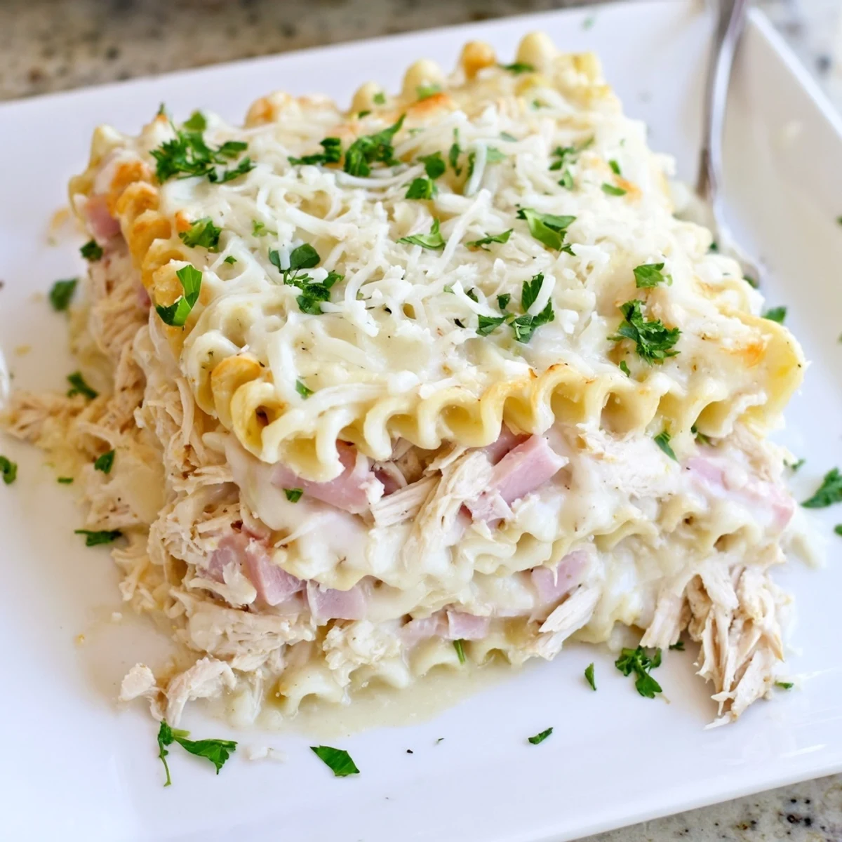 Golden-baked Chicken Cordon Bleu Lasagna layers bubbling Swiss cheese and ham between tender pasta sheets