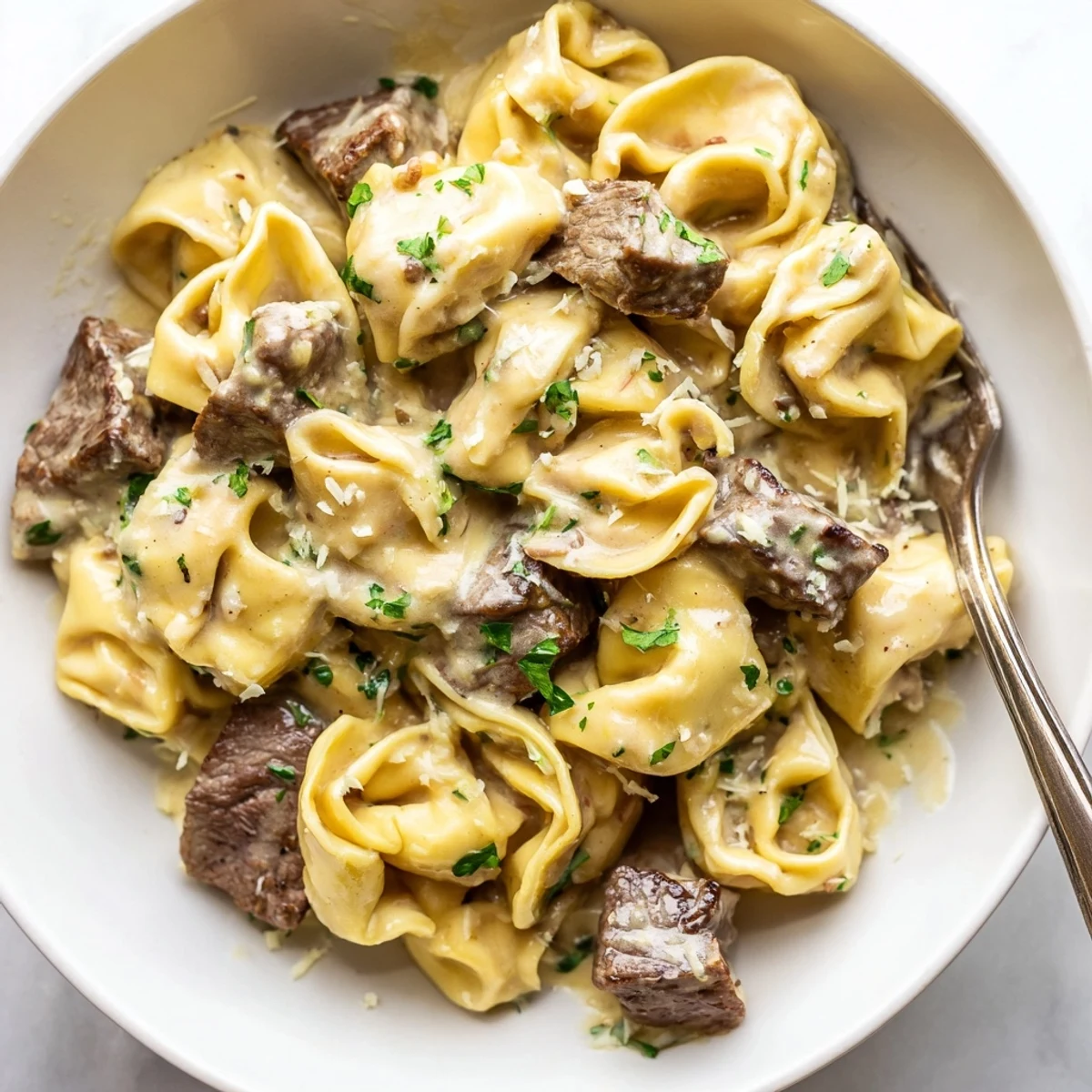 Skewered garlic steak tortellini bites drizzled in rich cream sauce on rustic plate
