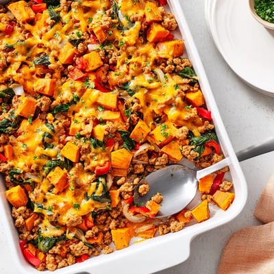 A hearty serving of Ground Turkey Sweet Potato Bake on a plate with a side salad for a wholesome dinner.