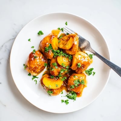 Tender Classic Apricot Chicken served hot over fluffy white rice with fresh parsley and apricot slices.  