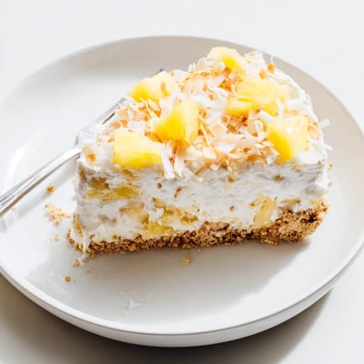 Tropical no bake pineapple coconut cream cake with fluffy whipped layers on a graham cracker crust